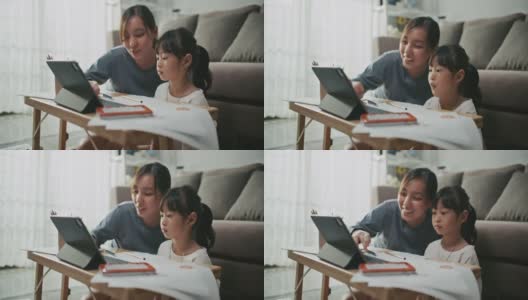 母亲帮助女儿使用笔记本电脑进行家庭教育高清在线视频素材下载