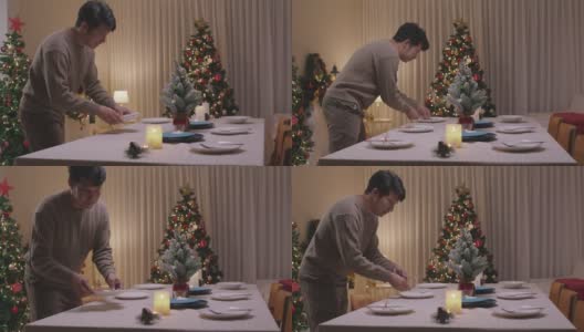 亚洲单身男子今晚准备圣诞夜餐桌布置派对。高清在线视频素材下载