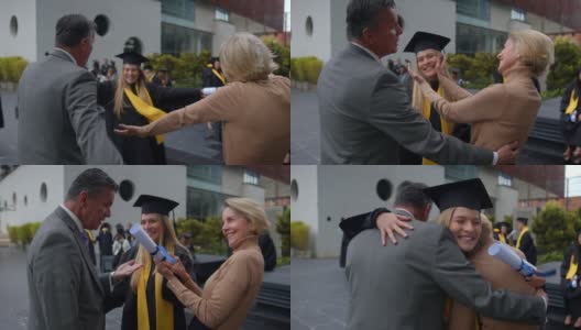 大学毕业典礼后，一个快乐美丽的年轻女子兴奋地拥抱她的父母高清在线视频素材下载