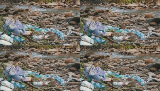 山上流得快干净，岸上有岩石，里面有垃圾、塑料瓶、塑料袋。环境污染中的人为因素。特殊的垃圾散焦高清在线视频素材下载