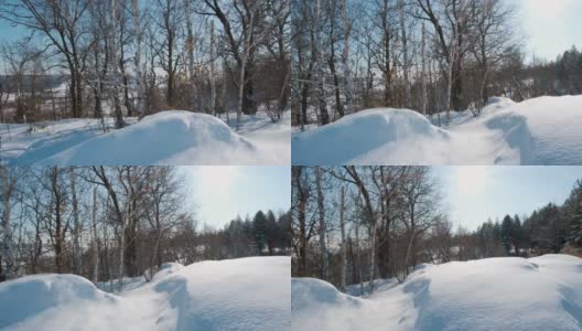 白色的雪躺在绿色的松树和桦树的树枝上，相机移动，覆盖了整个被雪覆盖的冬天的树木。高清在线视频素材下载