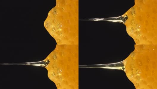 (实时和垂直)蜂蜜从蜂巢流动高清在线视频素材下载