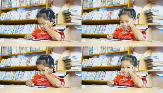 亚洲小女孩穿着中国衣服在图书馆画画高清在线视频素材下载