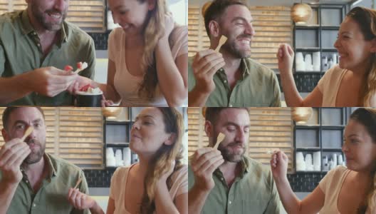 愉快的拉丁美洲夫妇在一个约会分享冰淇淋，同时交谈和微笑高清在线视频素材下载