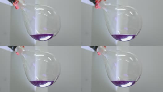 玻璃灯泡在实验室蒸发器中旋转。科学医学实验室。一种用于液体蒸发的装置。烧瓶在旋转。研究和搜索。试管中的紫色液体。高清在线视频素材下载