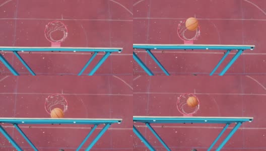 上角篮球篮板。橘黄色的篮球在户外覆盖着树叶的红色球场上投进目标并得分高清在线视频素材下载