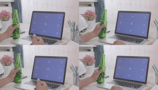 商人用电脑端着啤酒，桌上有蓝屏高清在线视频素材下载
