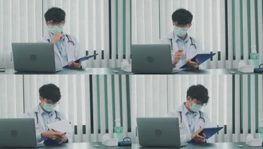 一位亚洲医生正在用笔记本电脑工作，在办公室里写病人的病史。高清在线视频素材下载
