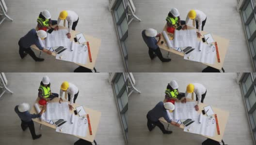 工程师和建筑师团队在施工现场进行建筑图纸的规划、测量。俯视图高清在线视频素材下载