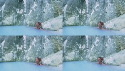 慢镜头:在意大利托斯卡纳的地热池和温泉中，一名成熟的女子正在洗澡。巴格尼圣菲利波天然热瀑布在早上没有人。森林中的白鲸。高清在线视频素材下载