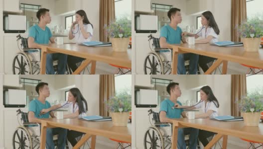 护理人员与坐在轮椅上的男患者交谈并进行健康检查高清在线视频素材下载