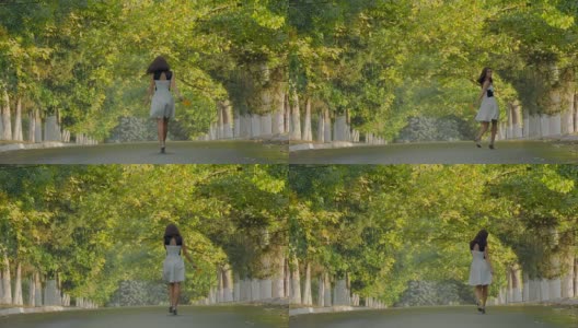 穿着衣服的漂亮女孩沿着小巷走着，远离镜头高清在线视频素材下载