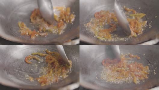 在炉子上的炒锅里用油煸炒新鲜的红辣椒，用勺子把炒熟的蔬菜放在炒锅里高清在线视频素材下载