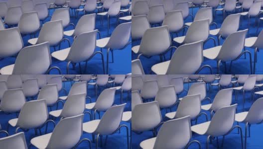 蓝色背景上的白色空椅子排成一排高清在线视频素材下载