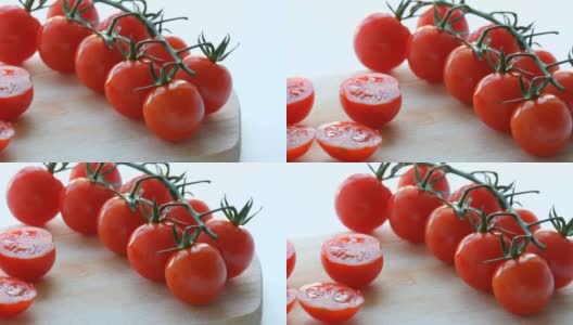 漂亮多汁的成熟切红樱桃番茄簇在白色的桌子背景和木制的厨房板高清在线视频素材下载