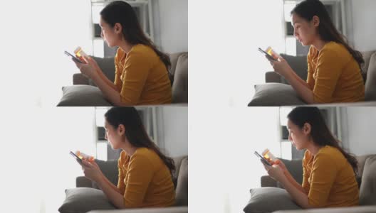 年轻的亚洲妇女拿着药瓶和打电话高清在线视频素材下载