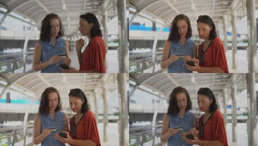 年轻的亚洲女人用信用卡在手机上购物高清在线视频素材下载