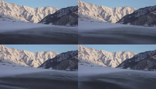 冬季飘雪的阿尔泰公路，在Chemal地区，以积雪覆盖的山脉为背景高清在线视频素材下载