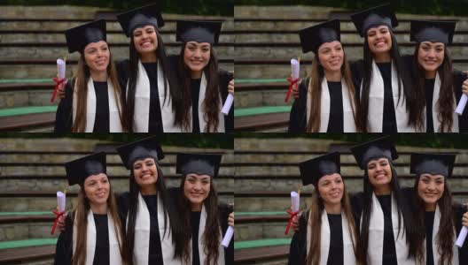 甜蜜的一组三个女性朋友看着相机微笑庆祝他们刚刚毕业高清在线视频素材下载