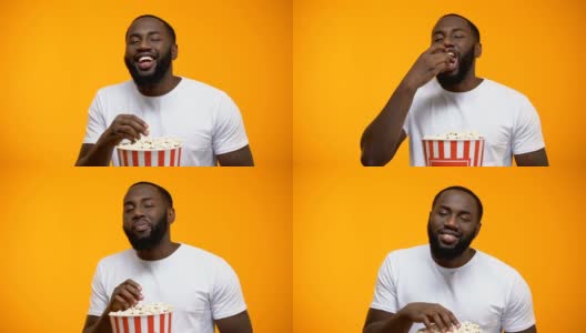 快乐的非裔美国人吃着爆米花大声笑着，喜剧表演高清在线视频素材下载