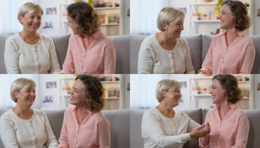 妈妈和女儿在沙发上大笑，分享好消息，互相信任的谈话高清在线视频素材下载