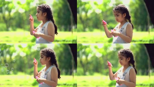 在夏日公园里吹肥皂泡的微笑女孩高清在线视频素材下载