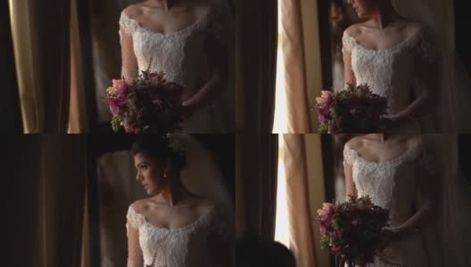 新娘手持花束，在婚礼前透过窗户看高清在线视频素材下载