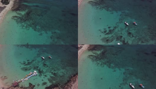 从无人机上看，在一个透明的绿松石海旁边的沙滩上有岩石的底部和岩石高清在线视频素材下载