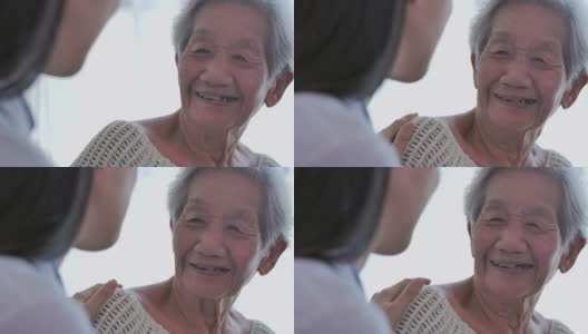 亚洲老年妇女听亚洲年轻女护士医生在咨询和手握她的年长女性病人在家。在家里照顾者高清在线视频素材下载