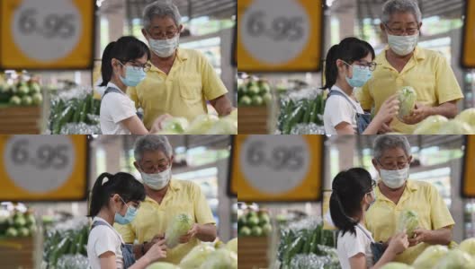 一个活跃的亚洲华人老人和他的孙女在购物和挑选白菜高清在线视频素材下载