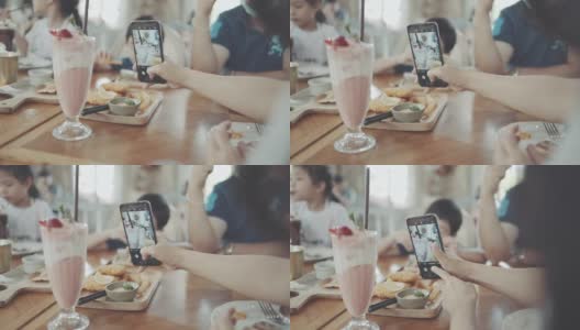 一个女人在咖啡店用智能手机拍照高清在线视频素材下载