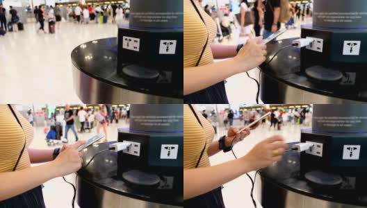 一名女子在机场候机楼的充电站给手机充电高清在线视频素材下载