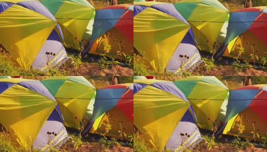 全视频高清旅行和露营概念，从彩色帐篷设置后，在山上移动的风与阳光和森林背景高清在线视频素材下载
