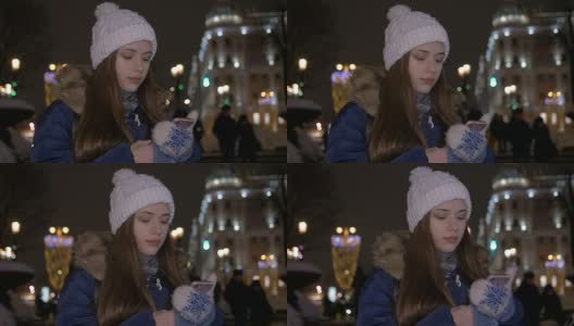一个戴着白色帽子的女孩，在冬天，走在街上，在智能手机上读信息。高清在线视频素材下载