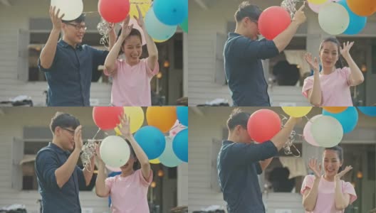SLO MO亚洲夫妇拿着彩色气球高清在线视频素材下载
