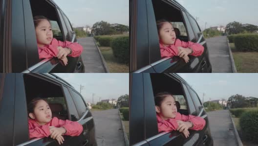 4K亚洲小女孩在车里找东西。早上，女孩在上学的路上看着车窗外的东西。孩子们在车里可以看到街景，放松心情。家庭在汽车概念。高清在线视频素材下载