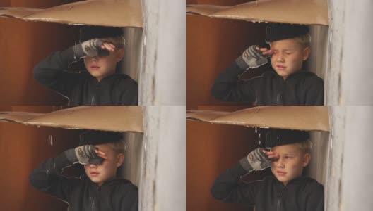 可怜的孤儿躲在纸板下避雨，哭着高清在线视频素材下载