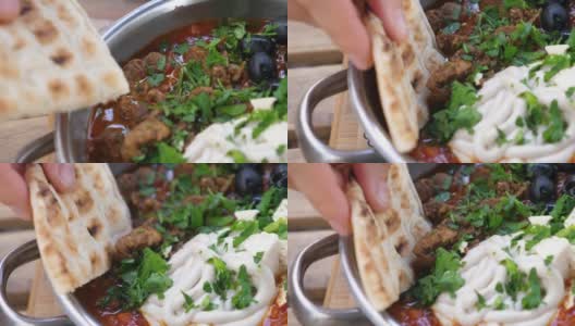 手蘸皮塔饼放在平底锅里。健康的中东有机烹饪高清在线视频素材下载