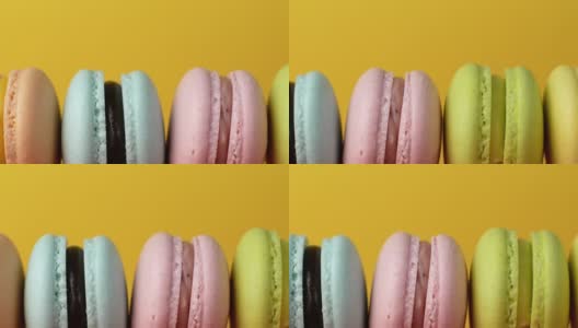 五彩马卡龙，法式马卡龙，甜美可口的甜点。孤立在黄色背景上。高清在线视频素材下载