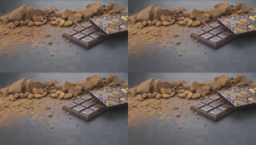 用杏仁做巧克力棒，甜点，手工糖果。由牛奶和黑巧克力块组成，可可粉在黑色背景上。桌上的糖果工艺品高清在线视频素材下载