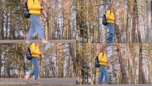 搭便车旅行的概念。一名年轻的女游客背着黄色夹克的背包，手里拿着保温瓶，沿着松树林走着。慢镜头,4 k高清在线视频素材下载