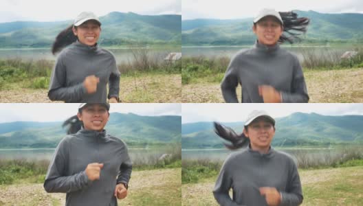 一个运动员在湖边的森林小径上奔跑。女跑步者早上在大自然中跑步。锻炼健康的生活方式。高清在线视频素材下载