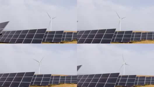 太阳能电池板旁边的一个风电场，可再生能源的概念，环保主义和清洁的电力来源高清在线视频素材下载