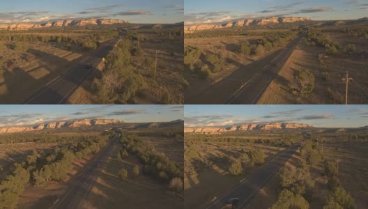 空中黑色SUV汽车沿着空荡的道路驶向犹他州的mesa山高清在线视频素材下载