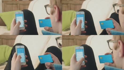 年轻男子在智能手机上填写信用卡号，为网上购物付款高清在线视频素材下载