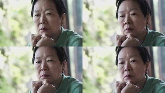 视频中亚洲资深女性手放在脸上思考，担心和悲伤高清在线视频素材下载