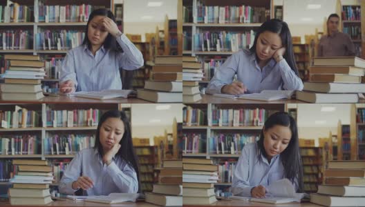 一个年轻的亚洲女孩正坐在大图书馆的书桌前重写课本。她疲惫不堪，看了看合上的书，转身走开了高清在线视频素材下载