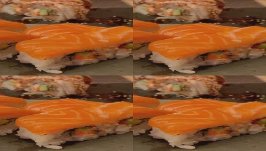 日本的食物。用筷子从木板上抓起鲑鱼寿司卷。高清在线视频素材下载