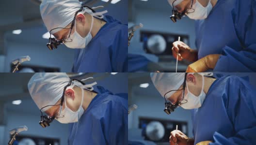 戴口罩的专业医生进行手术。头戴手术灯的外科医生用医疗器械给病人做手术。高清在线视频素材下载