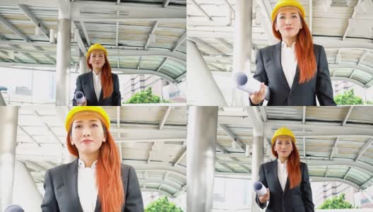 年轻貌美的亚洲工程师，穿着西装，戴着安全帽，走在办公楼的通道上高清在线视频素材下载